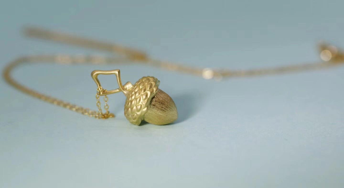 Macro shot of gold acorn necklace
