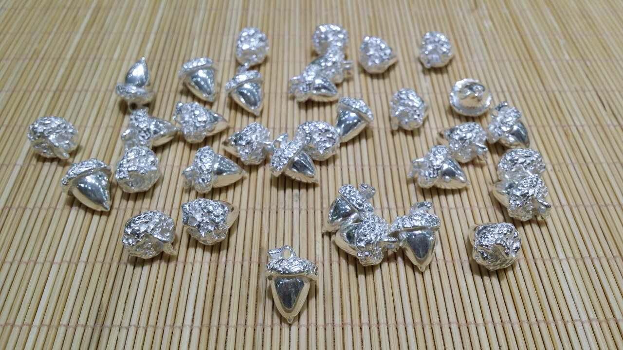 Collection of silver acorn charms Jim Cathcart gives as gifts