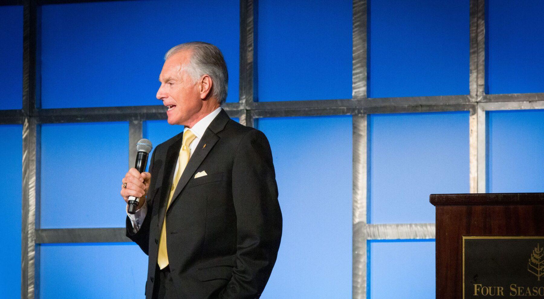 Jim Cathcart speaking on stage at the Four Seasons